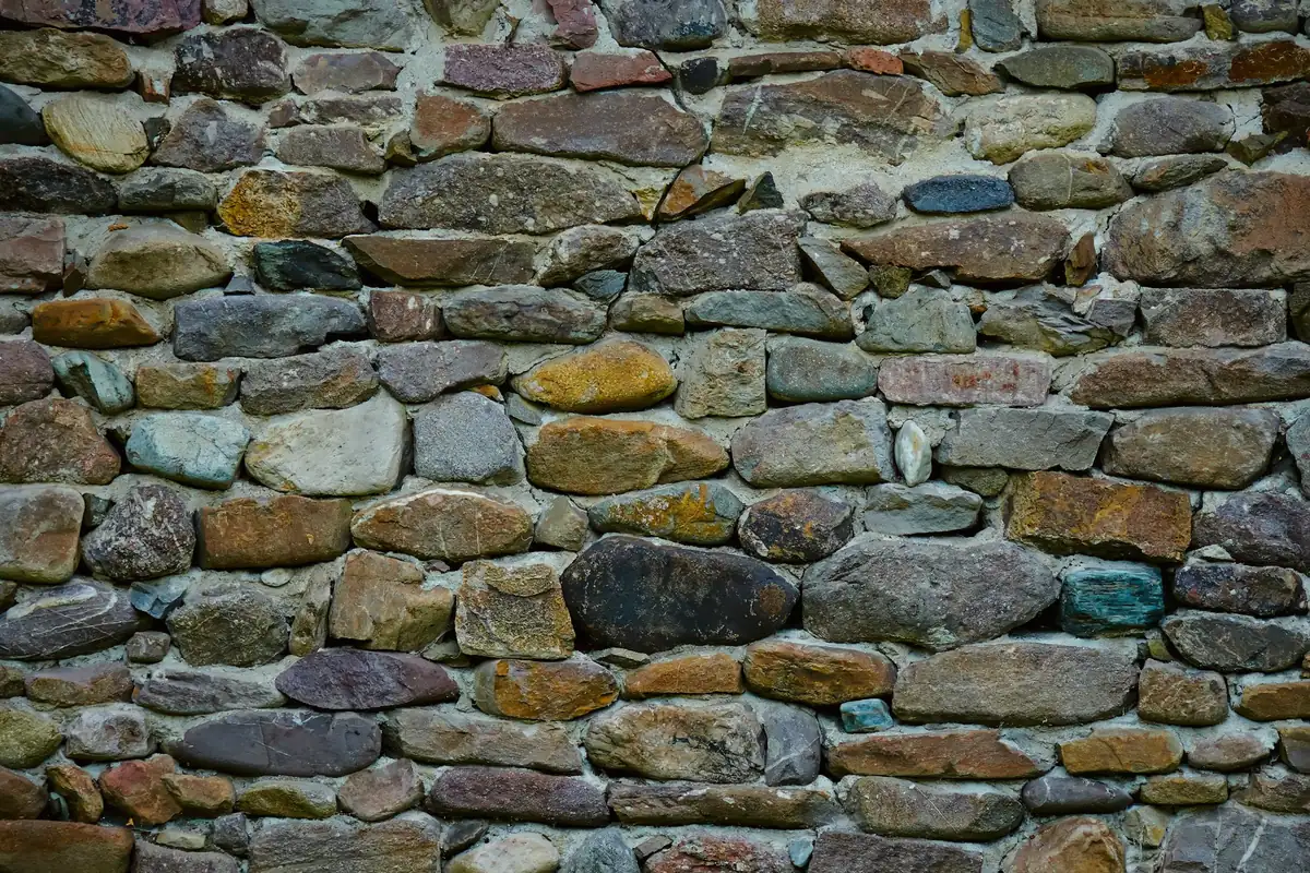 Mur de pierres sèches aux teintes brunes et grises, vu de près